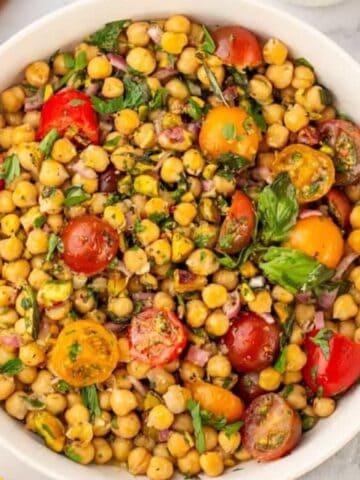 top view of a bowl of chickpea salad surrounded by ingredients.