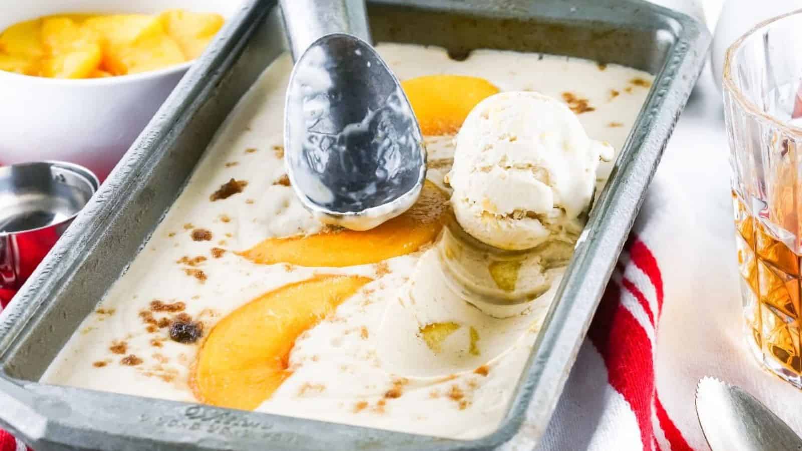 A tray of Cinnamon Bourbon Peach Ice Cream with a scoop.