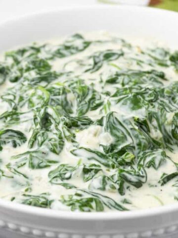 A close up image of creamed spinach in a bowl.