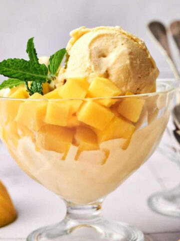 An image of Homemade Mango Ice Cream with fresh mango cubes underneath.