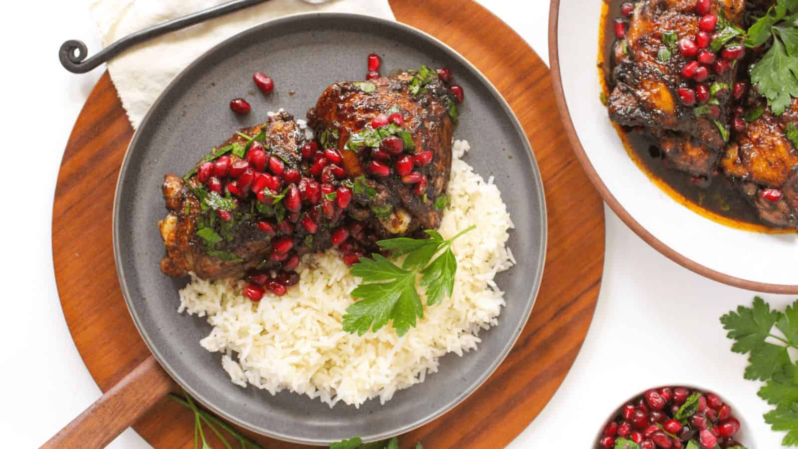 A plate of rice with Pomegranate Glazed Chicken Thighs.