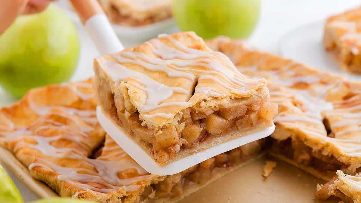 Someone holding a slice of Apple Slab Pie.