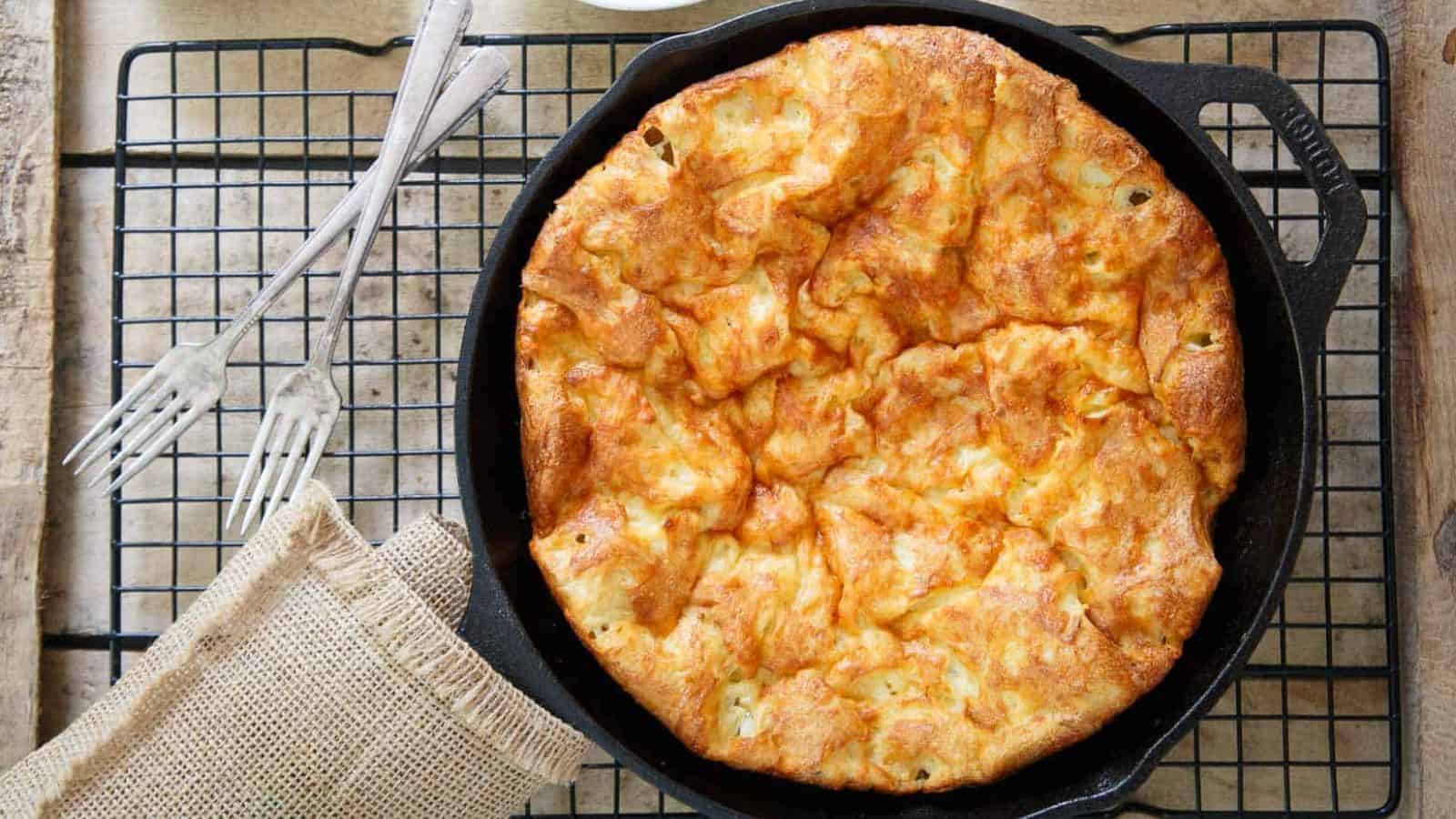 An overview of Cheddar Dutch Baby on a skillet.