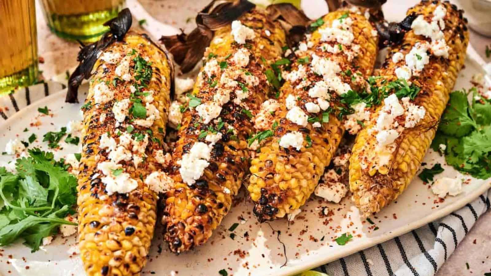 Four Grilled Corn on the Cob on a plate.