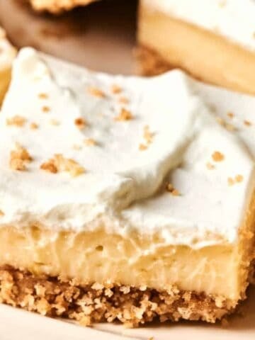 A close-up image of Key Lime Bars with a slice of fresh lime on the side.