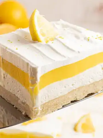 Someone holding a slice of Lemon Lush.