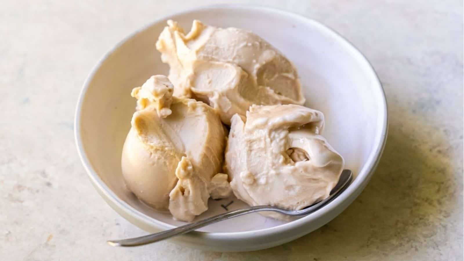 Three scoops of Ninja Creami Coffee Protein Ice Cream in a bowl with a spoon.