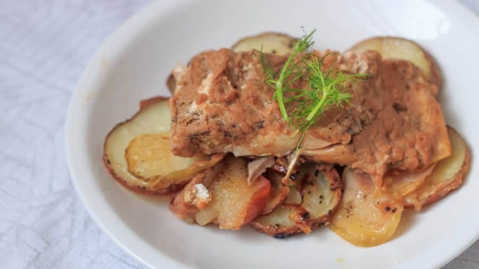 A plate of Baked Salmon with Apples and Potatoes.