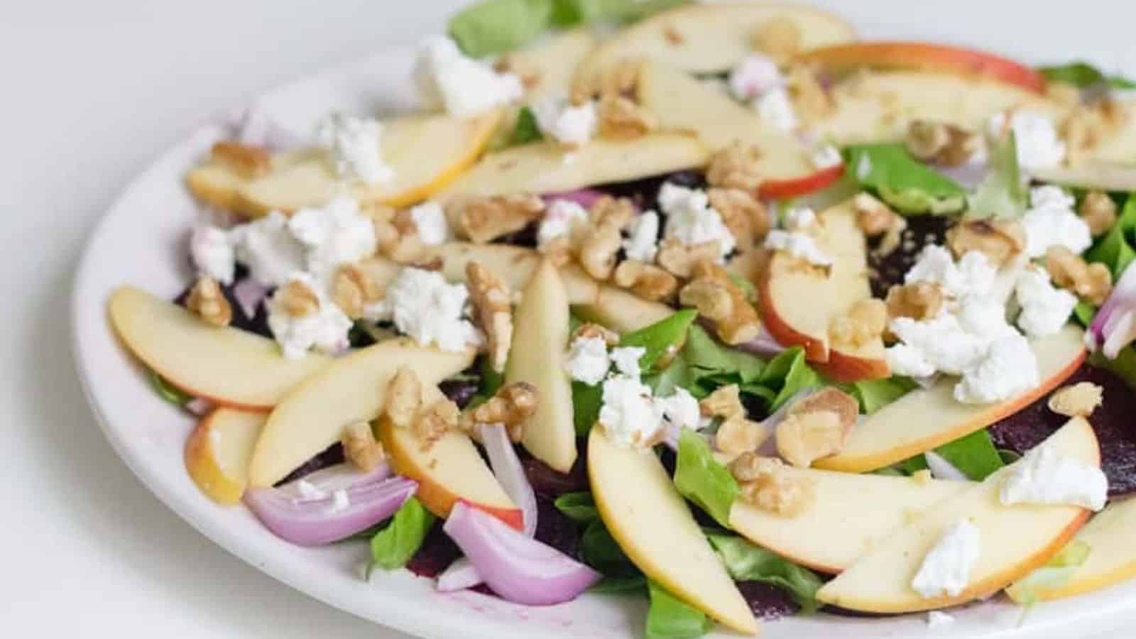 A plate of roasted beet, apple, and goat cheese salad.