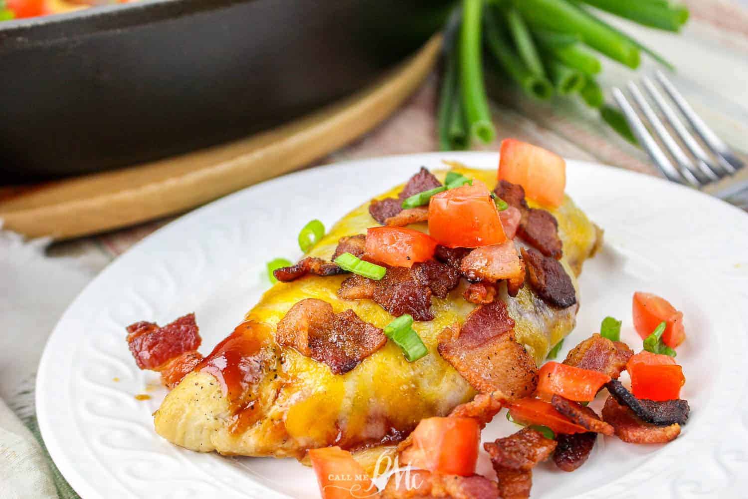 Cheese covered chicken in a skillet with a spatula.