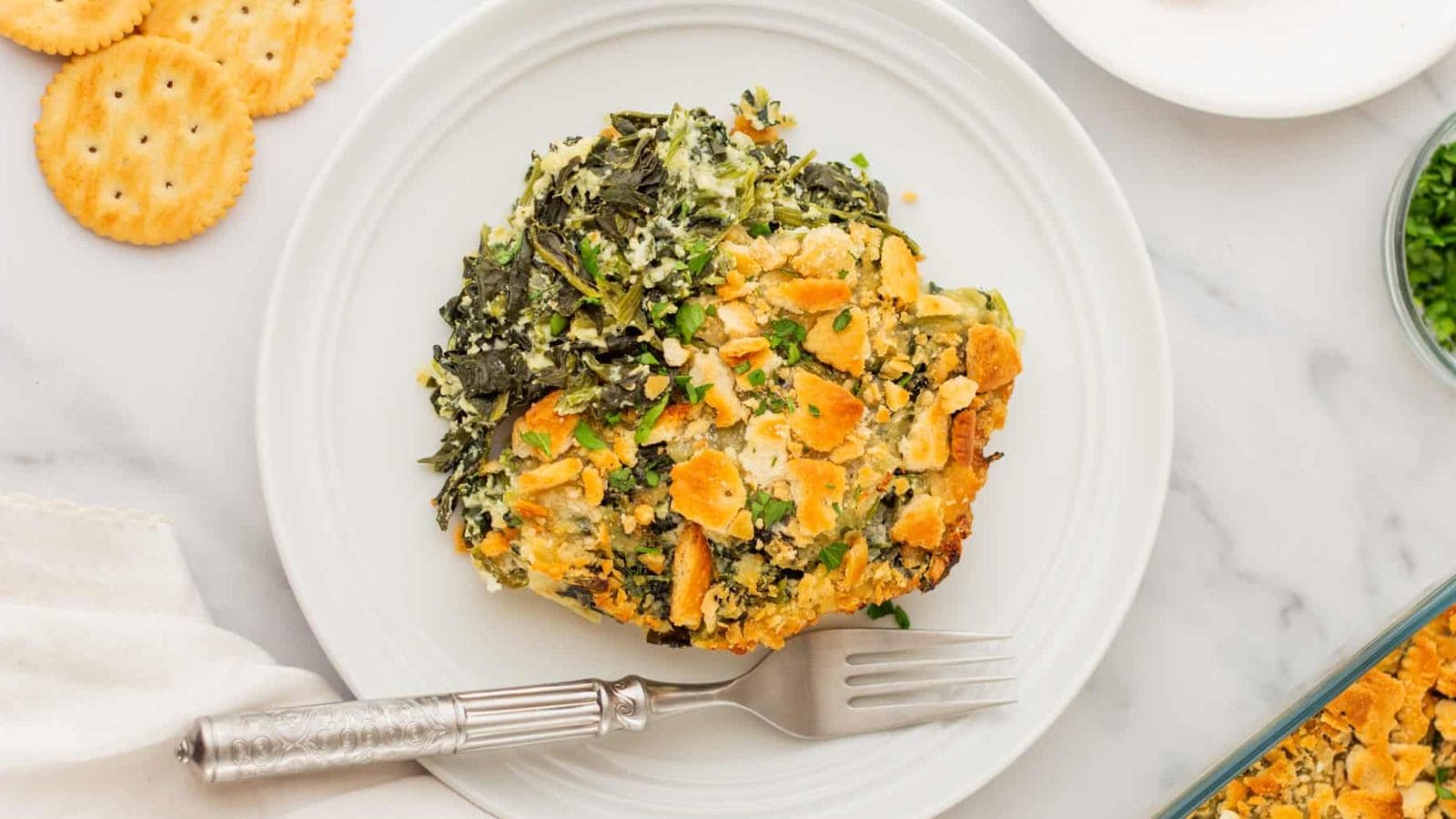 An overview of a plate of spinach casserole with a fork.