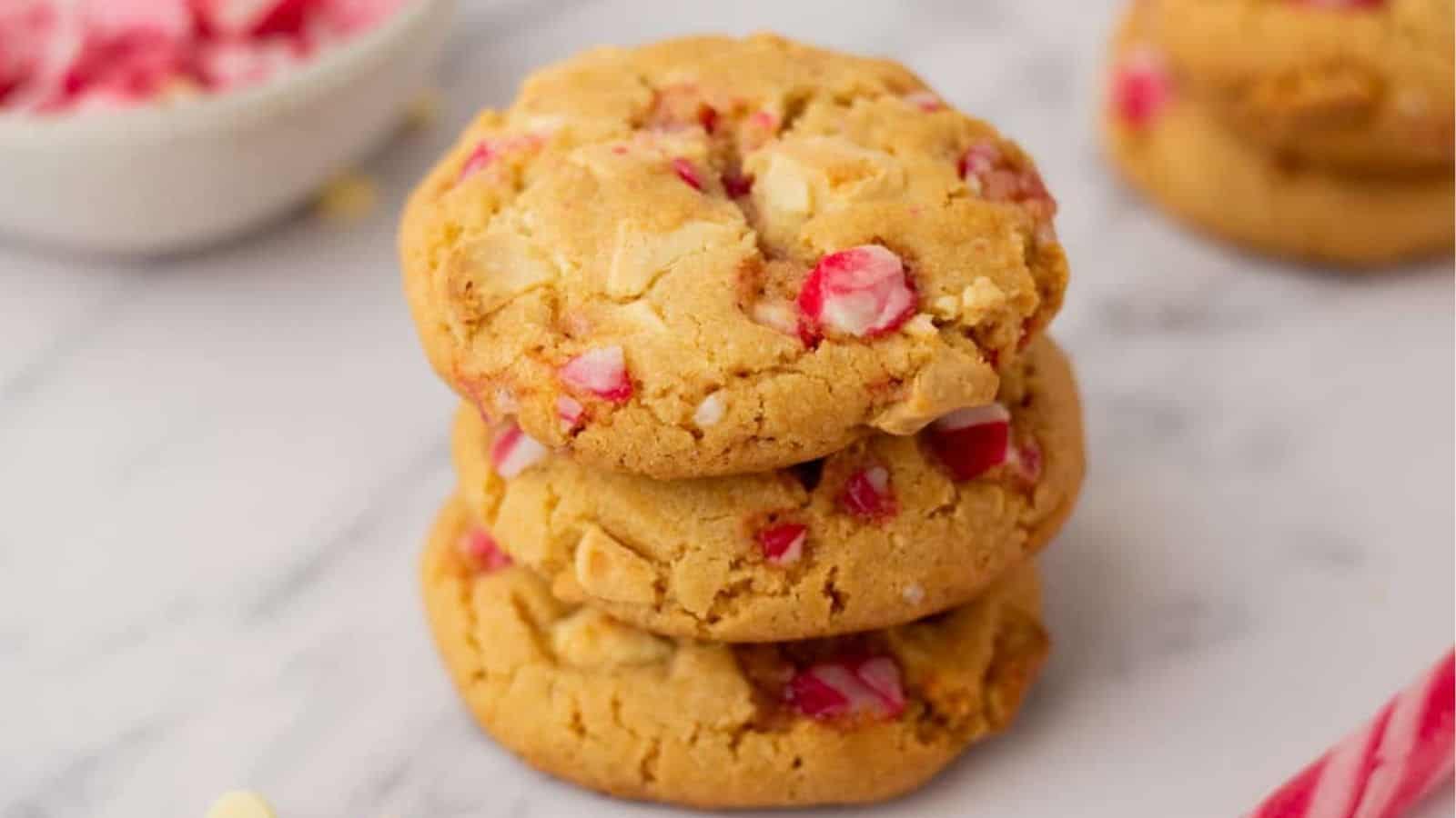 A close up image of white chocolate peppermint cookies stacked on top of each other.