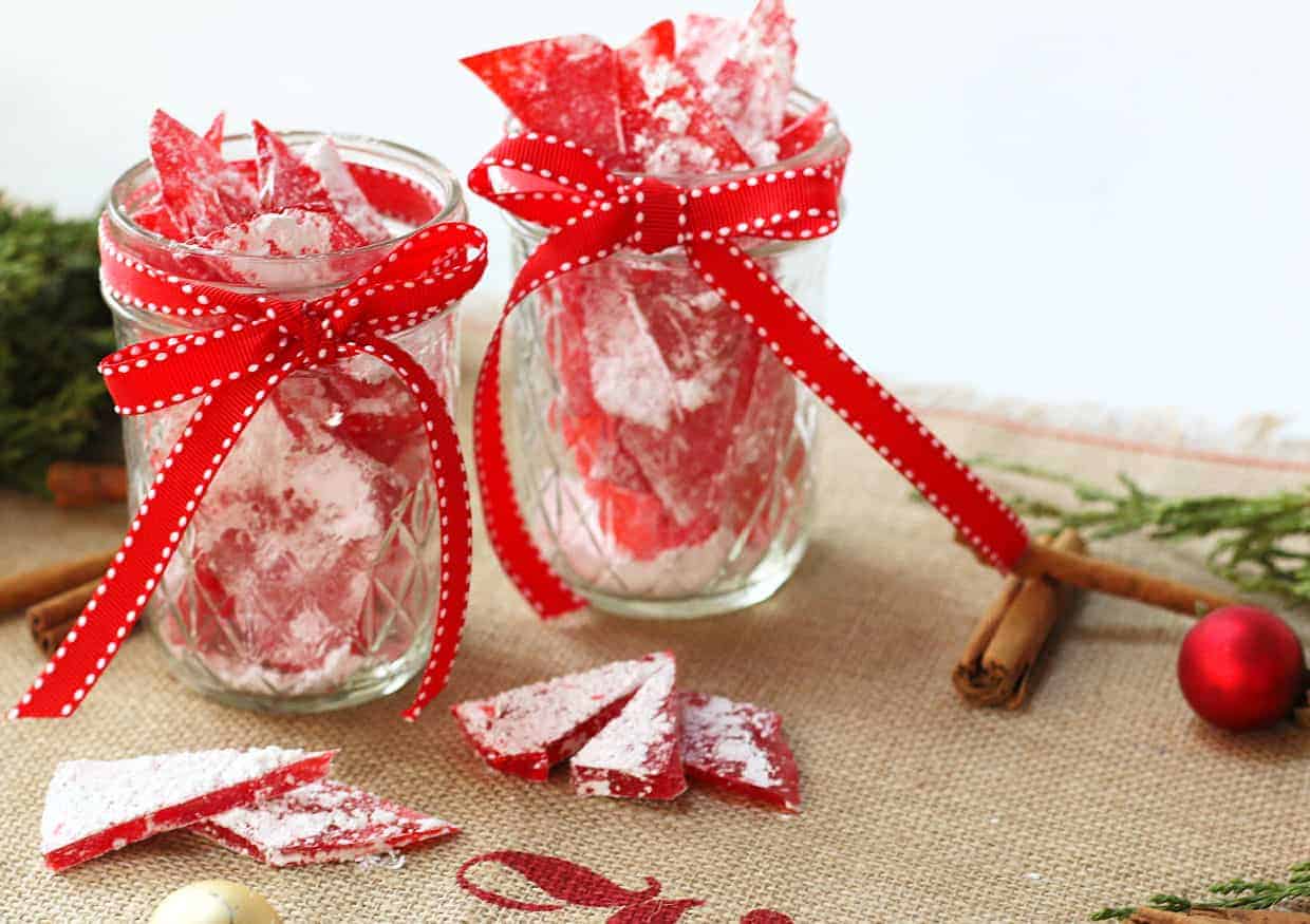 Cinnamon rock candy in glass jars with red ribbons.