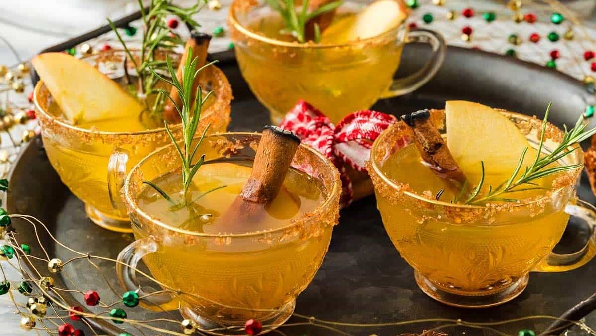 Four glasses of Spiced Holiday Punch on a tray.