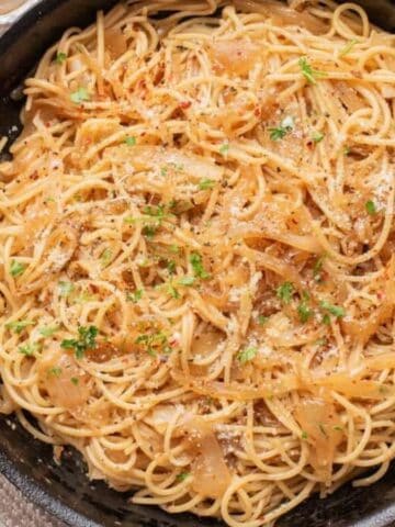 An overhead image of caramelized onion pasta in a. skillet.
