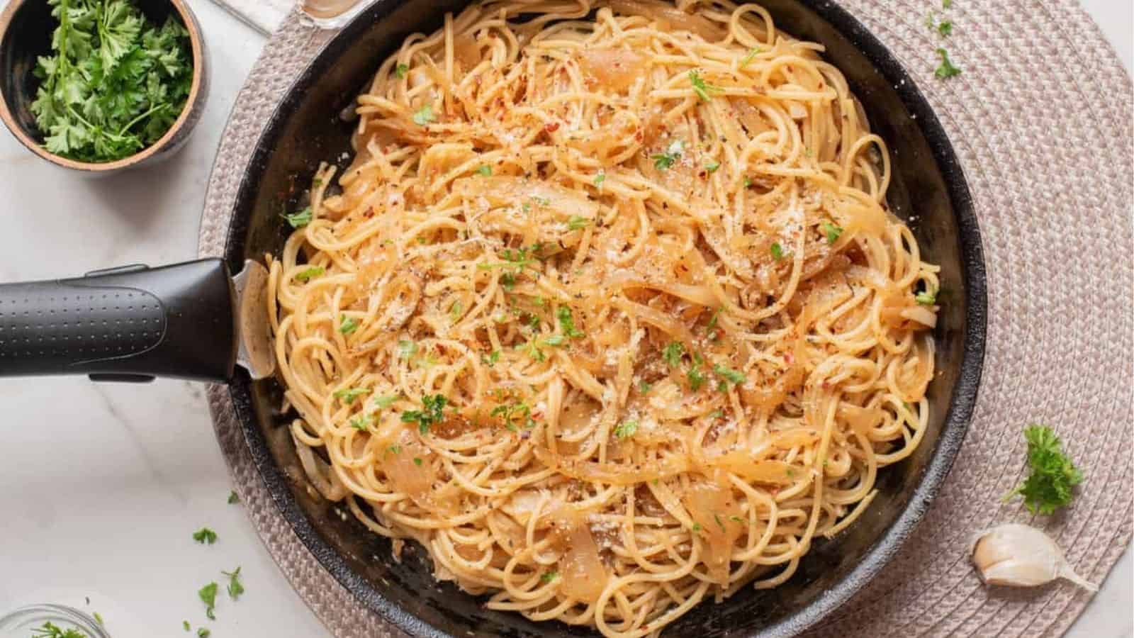 An overhead image of caramelized onion pasta in a. skillet.
