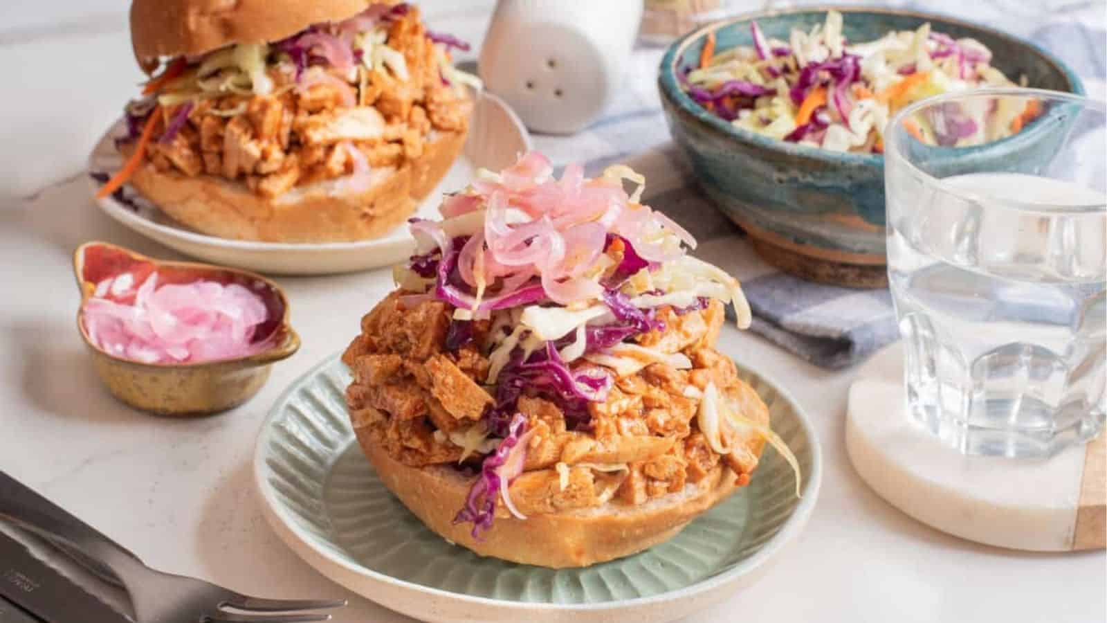 A close up image of BBQ tofu sandwich on a plate.