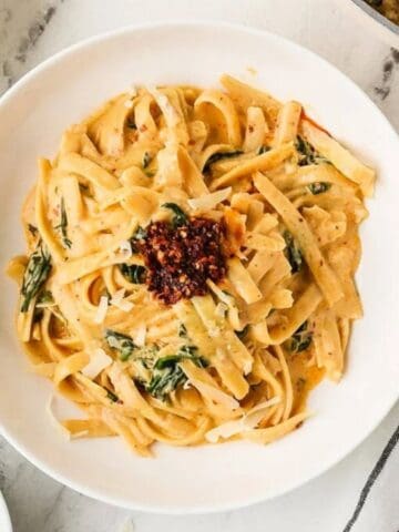 An overhead image of serving fettuccine alfredo on a plate.