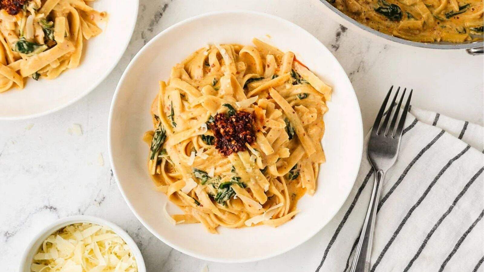 An overhead image of serving fettuccine alfredo on a plate.