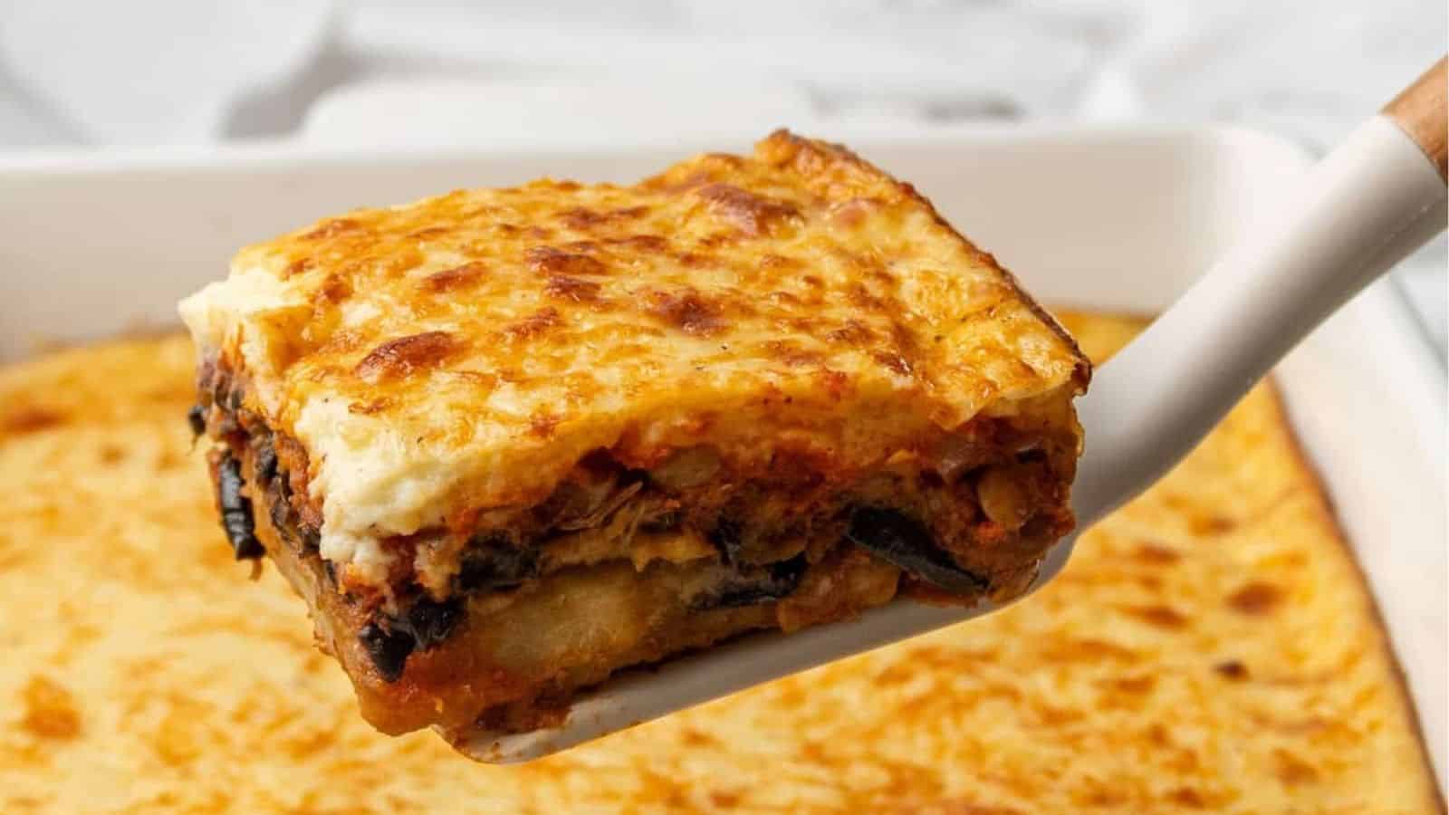 A close up image of a portion of vegetarian moussaka lifted up on a spatula.